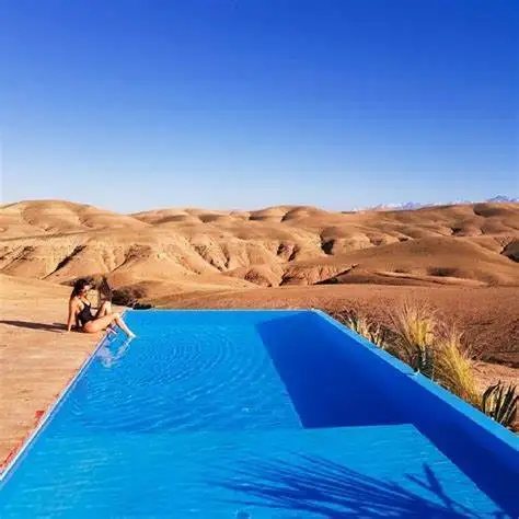 Une piscine entourée de zelliges et de palmiers à Marrakech